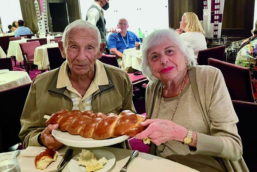 Frank and Esther sharing a challah at a Sabbath Eve dinner.